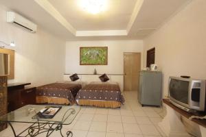 沙努尔阿里特海滩度假别墅酒店的一间酒店客房,设有两张床和电视