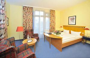 舍纳贝克浴疗公园酒店的酒店客房带一张床、一张桌子和椅子