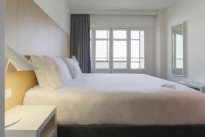 科英布拉科英布拉中心酒店的窗户客房内的一张大白色床