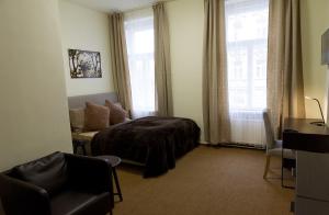 布拉格Light Rooms Prague的一间卧室配有一张床、一张沙发和一个窗口