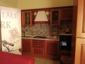 格罗塔列Sogni d'Oro的厨房配有木制橱柜和炉灶烤箱。
