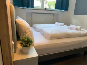 蒙绍besttime Hotel Monschau的一间卧室设有两张床和盆栽植物
