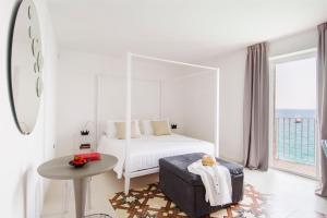 滨海波利尼亚诺Dimora Talenti的白色的卧室配有白色的天蓬床和桌子