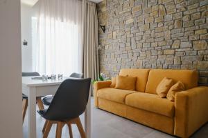 SerramezzanaCilento Victory House的客厅设有黄色沙发和砖墙