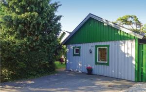 赫尔湾Cozy Home In Hllviken With Wifi的绿色和白色的建筑,设有车库