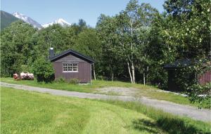 TokleCozy Home In Isfjorden With House A Panoramic View的两个人坐在棚屋前的长凳上