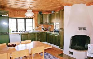 塔那比莱斯霍姆塔尔纳比度假屋的厨房配有桌子和壁炉