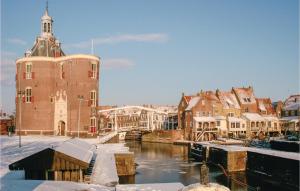 恩克赫伊曾Studio Aan De Gracht的一座有雪盖建筑的城市,一条河流