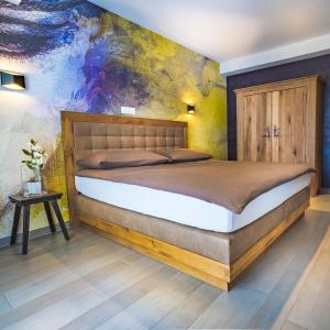 VionnazLe Manoir Vionnaz的卧室配有一张床,墙上挂有绘画作品