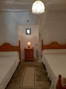 卡皮雷拉Casa Rocio的一间卧室配有两张床和床头灯。