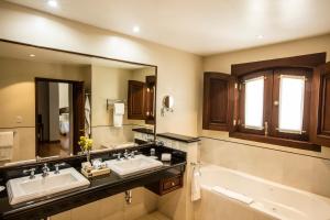 瓜纳华托玛丽亚克里斯蒂娜别墅酒店的浴室设有2个水槽、浴缸和镜子