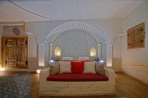 于尔居普Taru Cave Suites的一间卧室配有一张红色沙发的床