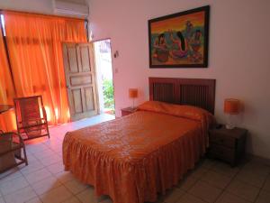 YurimaguasPosada Cumpanama的一间卧室配有一张带橙色床罩的床