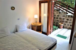 乌巴图巴Villa Félix Suites e Chalés的一间卧室设有一张床,并有通往阳台的门