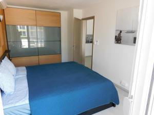 希欧福克K&K Apartment Siófok的一间卧室配有一张蓝色的床和木制床头板