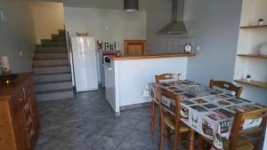 圣乌尔SEJOUR AU COEUR DES VOLCANS的厨房配有桌椅和冰箱。
