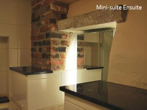 科尔切斯特北方山丘酒店的厨房配有镜子和砖墙