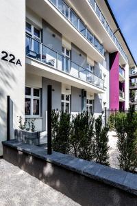 琴斯托霍瓦Apartamenty Nowa Kamienica Częstochowa Centrum Szymanowskiego 22A的公寓大楼拥有粉红色和白色