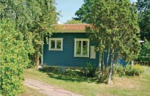 费尔耶斯塔登Gorgeous Home In Frjestaden With Wifi的蓝色房子,有红色屋顶和树木