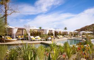 卡波圣卢卡斯Montage Los Cabos的一个带白色遮阳伞和椅子的度假游泳池