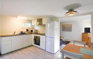Stenkullen1 Bedroom Amazing Home In Stenkullen的厨房配有白色冰箱和桌子