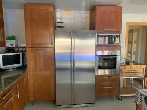 卡拉费尔Chalet moderno con PISCINA en Calafell的厨房配有不锈钢冰箱和微波炉。