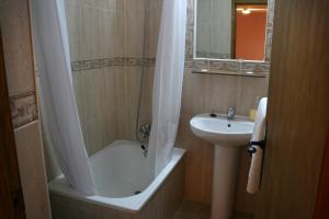 特鲁希略马约尔广场旅馆的带浴缸、水槽和淋浴的浴室