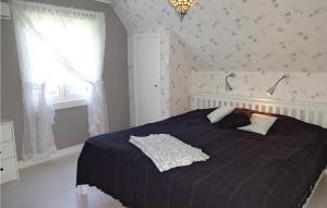 MöljerydAmazing Home In Kallinge With Kitchen的一间卧室配有一张带蓝色棉被的床和窗户。