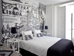 里斯本里斯本艺术酒店的卧室配有白色的床和带海报的墙壁