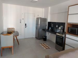 马塞约Apartamento de alto luxo.的厨房配有不锈钢冰箱和桌子