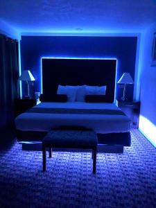 俄克拉何马城Budget Inn & Suites的一间卧室配有一张蓝色灯光的大床