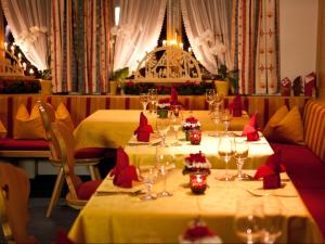 莱赫阿尔贝格Haus Odo的一间用餐室,配有两张红色餐巾桌