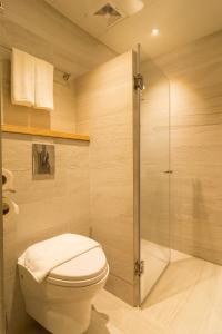 爱妮岛库纳酒店 的一间带卫生间和玻璃淋浴间的浴室
