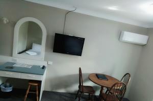 麦夸里港艾瑟思尔汽车旅馆的客房设有书桌、桌子和电视。
