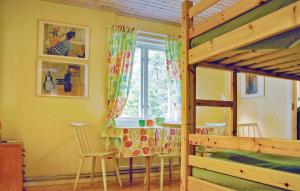 费尔耶斯塔登Gorgeous Home In Frjestaden With Wifi的一间卧室配有桌椅和一张双层床。