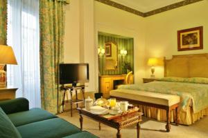 里斯本艾薇达宫殿酒店的酒店客房,配有床和电视