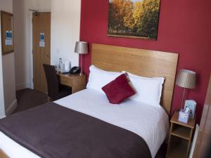 科尔切斯特北方山丘酒店的一间卧室设有一张红色墙壁的大床