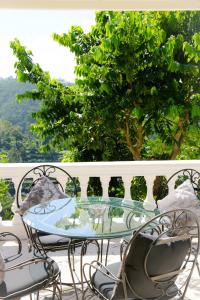 贝都古Pondok Plantation Luxury Mountain Escape Bedugul的阳台上的玻璃桌子和椅子