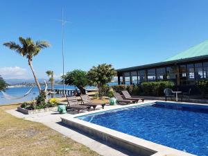 劳托卡Belo Vula Island Resort Limited的一座与度假村相连的建筑旁边的游泳池