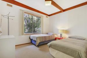 梅顿苍鹭升起度假屋的一间卧室设有两张床和窗户。