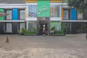 万隆RedDoorz At Hotel Arimbi Dewi Sartika Baru的前面有街道的建筑