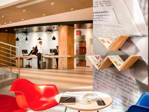 斯法克斯Ibis Sfax的一个带红色椅子、桌子和书桌的办公室