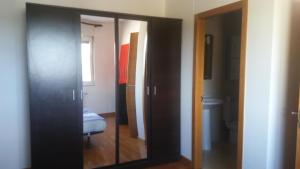 卢戈Precioso apartamento的客房设有镜子和带卫生间的浴室