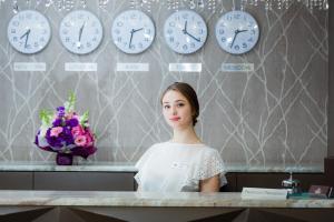 基辅水晶酒店的站在墙上挂着时钟的柜台上的女人
