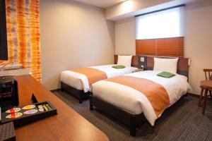 滨松Kitanoniwa The Kuretakeso的酒店客房设有两张床和电视。