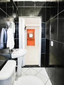 圣保罗OYO Hotel Boneville, São Paulo的一间带白色水槽和红色门的浴室