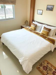 邦萨雷邦萨雷班苏克丽度假村的卧室内的一张大白色床,带有窗户