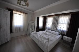 塞尔丘克Queen Bee Hotel的卧室配有白色的床和2扇窗户。