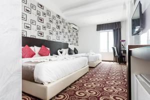 马六甲E-Red Hotel Melaka的两张位于酒店客房的床铺,配有红色枕头