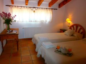 Lliber芬卡厄尔尼诺科拉尔乡村民宿的酒店客房设有两张床、一张桌子和一个窗户。